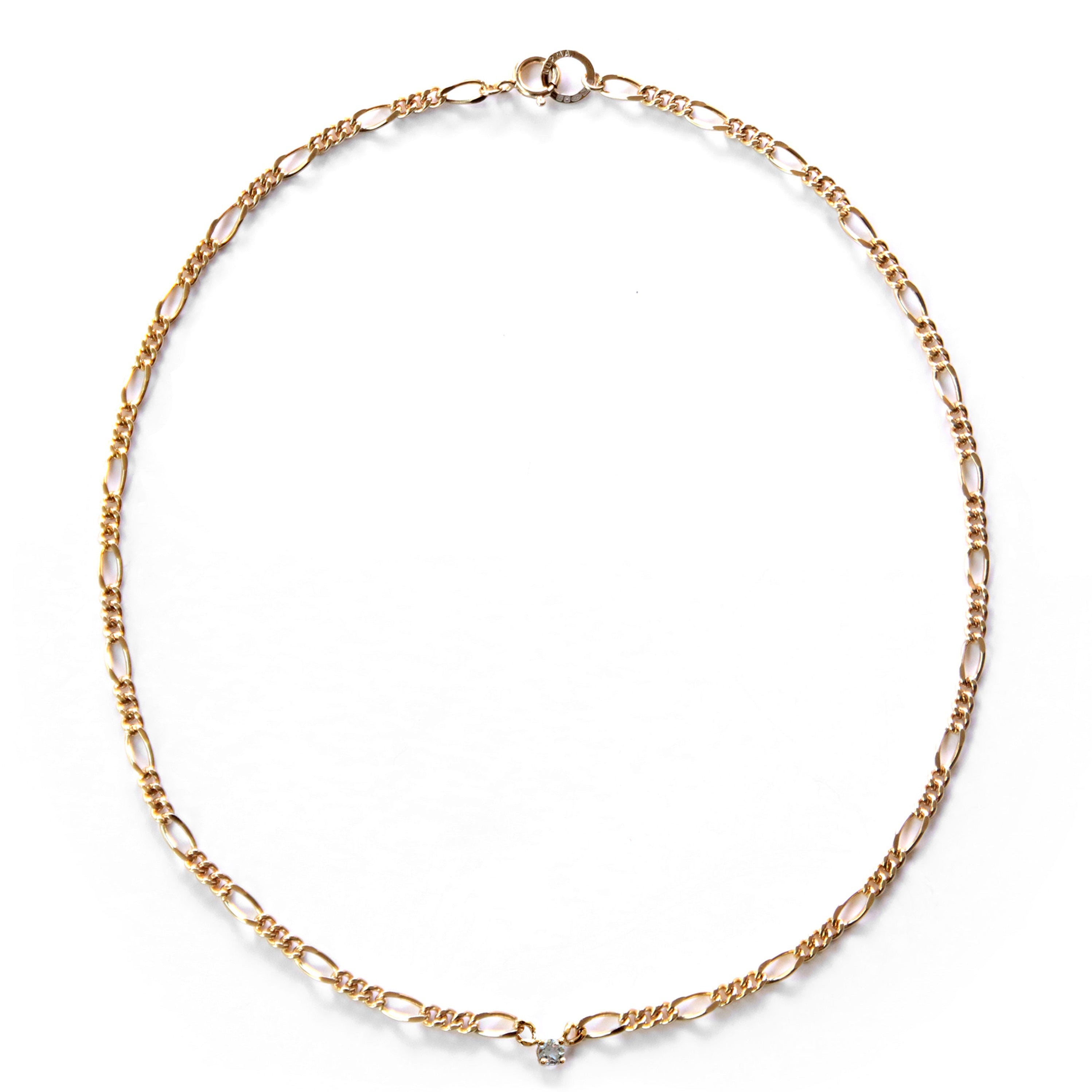 Gold chain necklace with small aquamarine stone on a white background