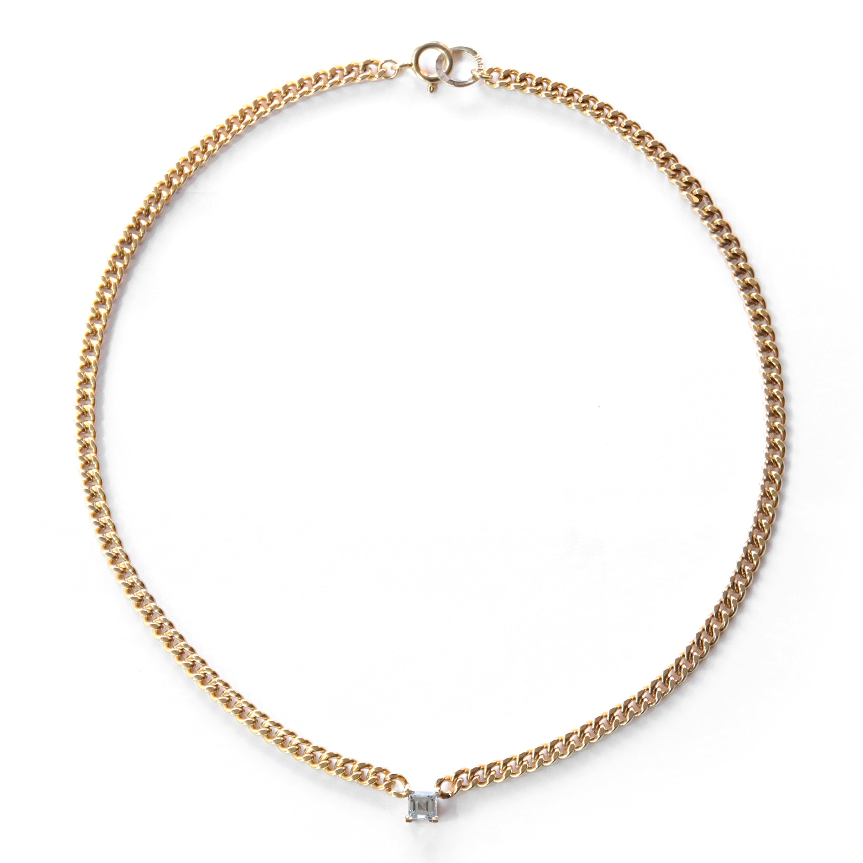 Gold chain necklace with a small diamond pendant on a white background