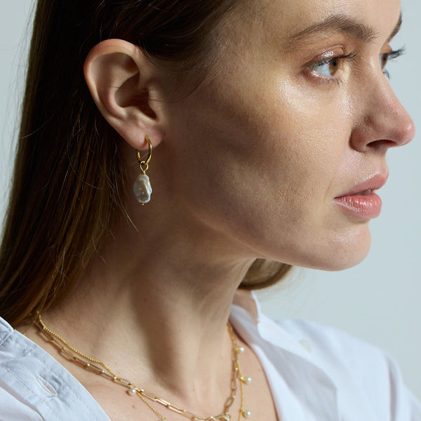 The perfect everyday gold hoop earrings entirely handmade with sustainable materials and available in three sizes. The stunning white Keshi pearl charm can be removed and used as a necklace pendant.  Sustainable materials are 14 Carat gold vermeil – recycled sterling silver dipped in with several layers of recycled 14 Carat gold.